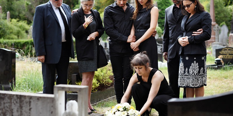 people lighting candles on grave